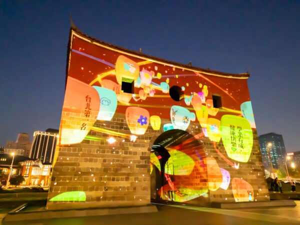 光雕展演「北門映像」首次加入互動式體驗，民眾透過手機掃描QR Code，便能將新年期許和祝福投影在北門上。圖／台北市觀光傳播局